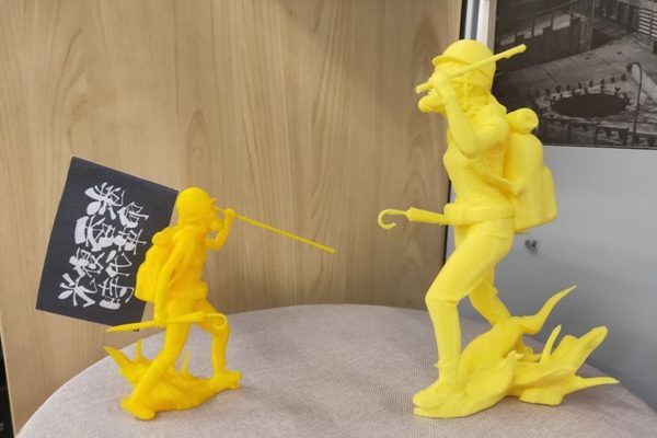 Two yellow printed maquettes with the flag