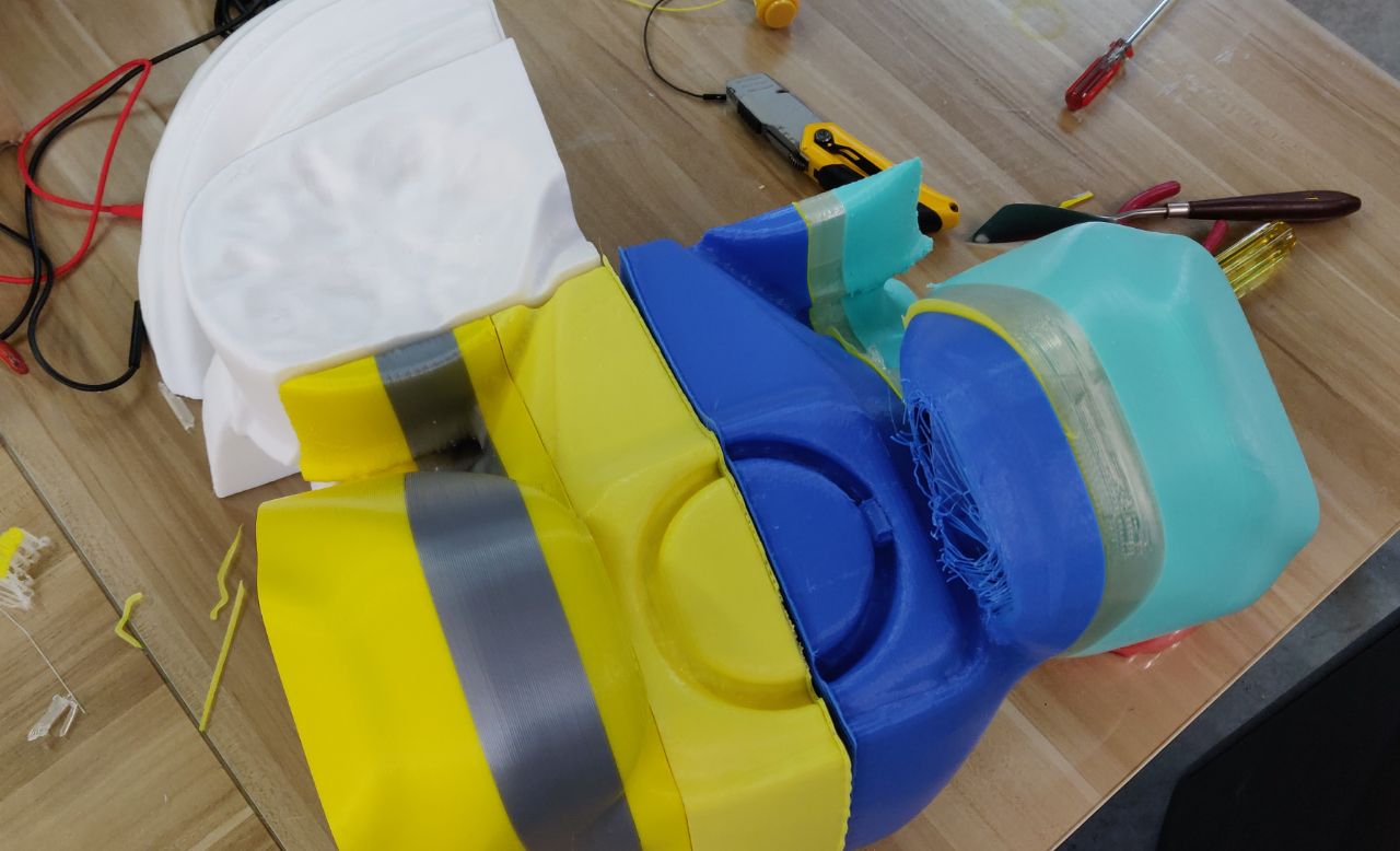 3D-printed head and helmet segments on a workbench