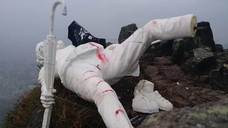 The statue toppled and defaced on the summit of Lion Rock